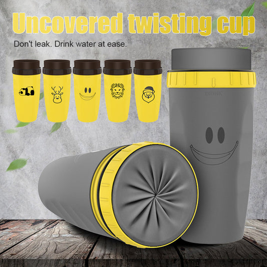 The image showcases a collection of travel cups called "Uncovered twisting cup" in two color variations: yellow with playful emoji designs and a plain grey one with a smiley face. The cups feature a unique twistable silicone membrane on the lid area, highlighted in grey on the yellow cups and yellow on the grey cup, demonstrating the product's lidless, leak-proof design.