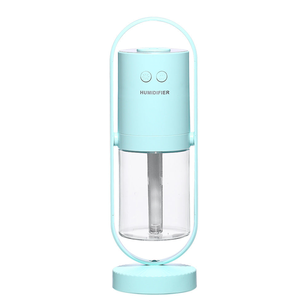A cylindrical blue USB air humidifier with a transparent water tank is cradled in a metallic arc stand.