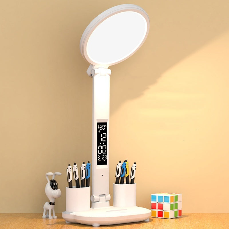 The LED clock table lamp displayed in a home office setting. It highlights the dimmable light and pen holder, great for reading and organizing.