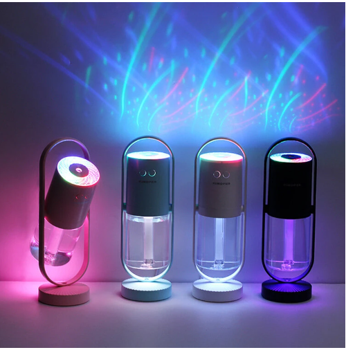 A row of four humidifiers in different colors showcasing vibrant projection lights creating a starry effect on the background.