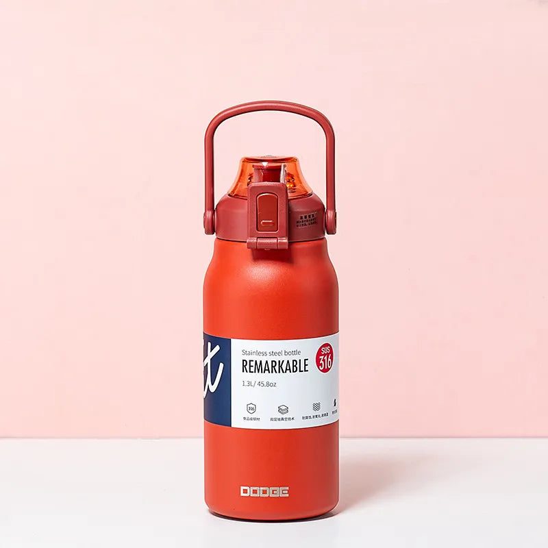 The image displays a matte red stainless steel thermal water bottle with a sturdy handle on the lid. The bottle is labeled "REMARKABLE 316", indicating the grade of stainless steel, and has a capacity of 1.3L/45.8oz as stated on its label