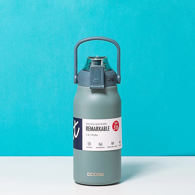 The image displays a matte cyan stainless steel thermal water bottle with a sturdy handle on the lid. The bottle is labeled "REMARKABLE 316", indicating the grade of stainless steel, and has a capacity of 1.3L/45.8oz as stated on its label