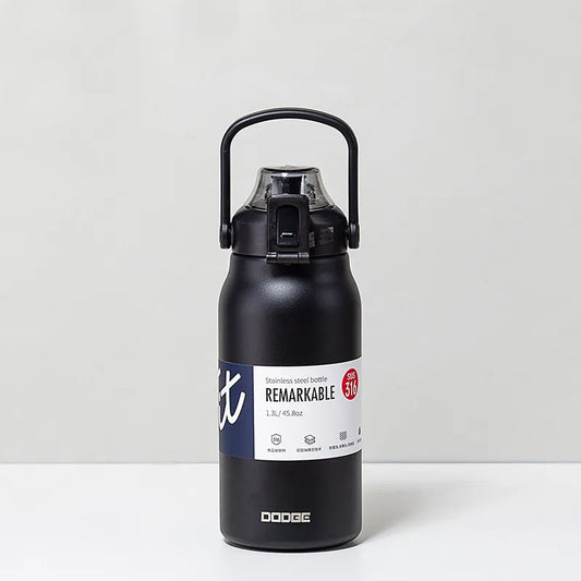 The image displays a matte black stainless steel thermal water bottle with a sturdy handle on the lid. The bottle is labeled "REMARKABLE 316", indicating the grade of stainless steel, and has a capacity of 1.3L/45.8oz as stated on its label