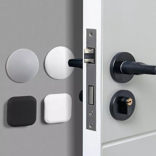 The image displays silicone door handle bumpers, both round and square-shaped, in black and white. These are small, self-adhesive pads that attach to the wall to prevent damage from door handles.  🌐 Sources