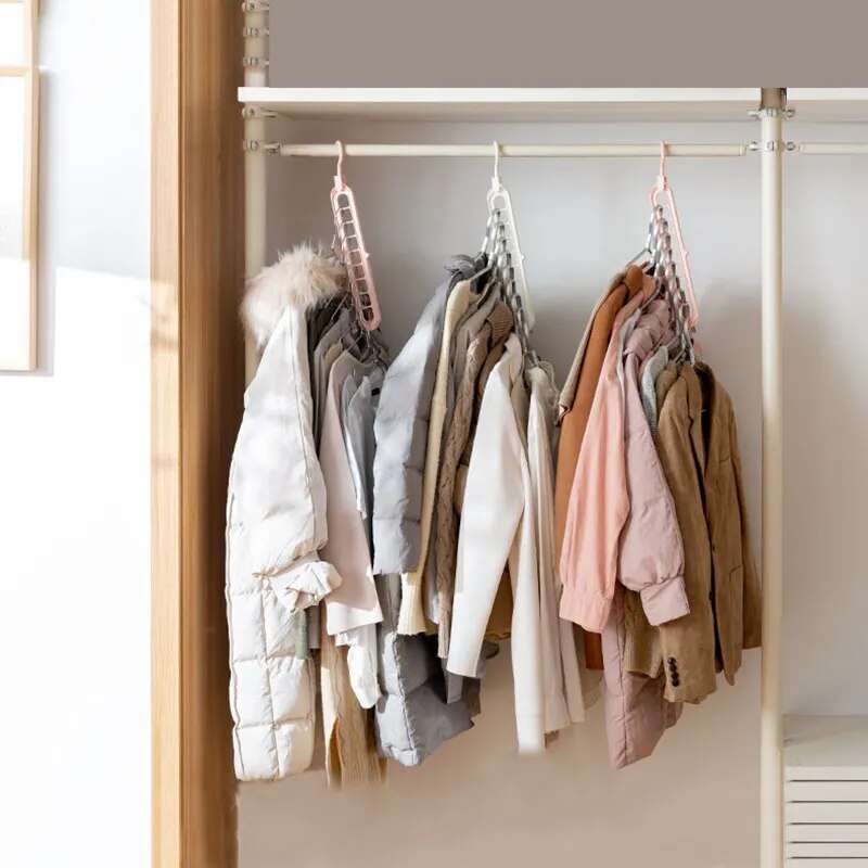 Several coats and jackets in different materials are organized on a gray multi-port clothes hanger, showcasing the hanger's strength and capacity.