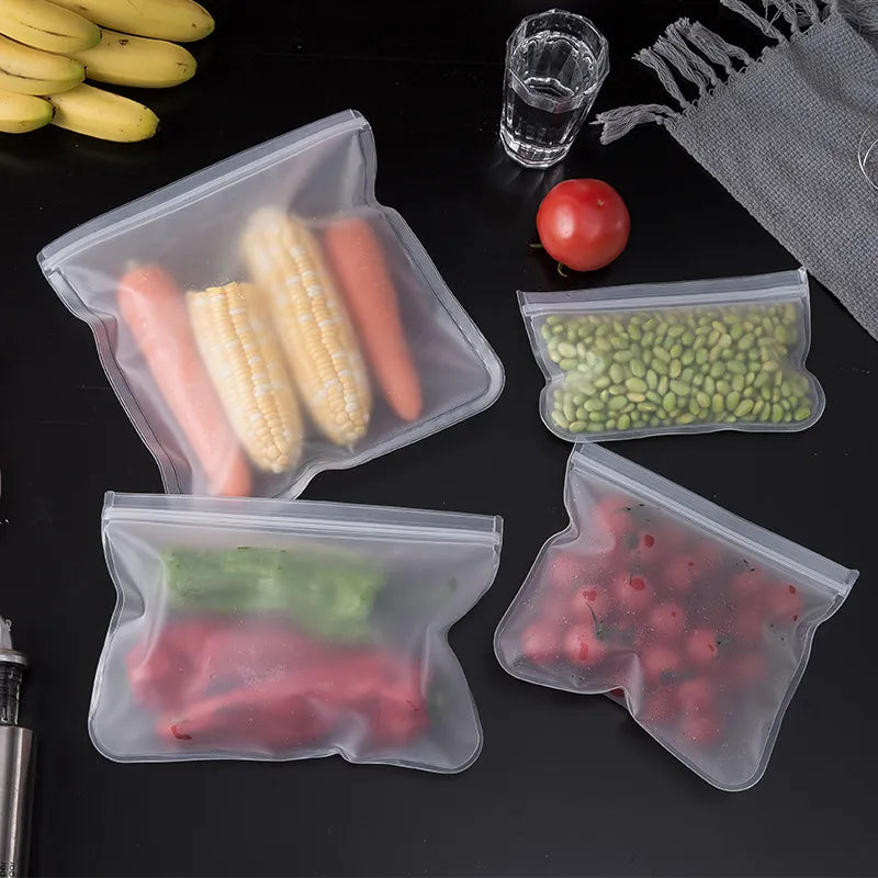 Multiple silicone storage bags in a refrigerator containing different foods including sandwiches, showcasing their use in food organization.