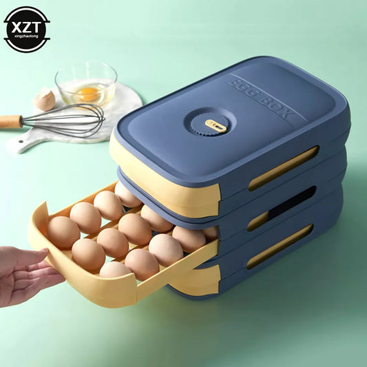 The image shows a navy blue and tan stackable egg storage container with a unique drawer design. A hand is pulling out one of the drawers, revealing several eggs nestled in individual compartments. Above the egg box, there is a whisk and a half-cracked egg on a clear dish, suggesting the container's use in a kitchen setting.