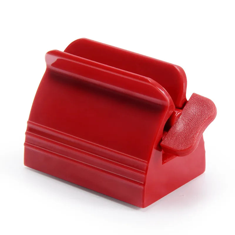 A single red toothpaste squeezer is shown from a side angle, displaying its compact design.