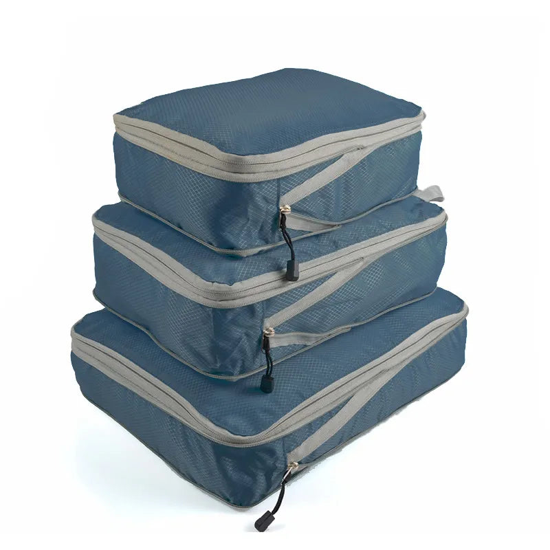 Three nylon packing cubes with mesh tops, in different sizes, stacked on top of each other.