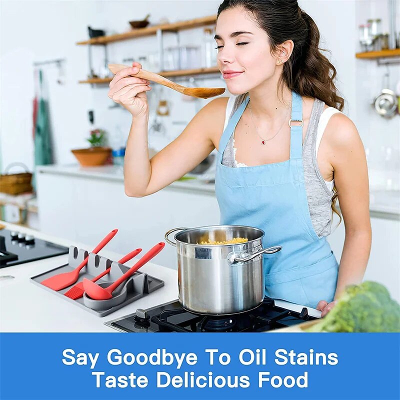 This image shows a grey silicone spoon rest and utensil holder, featuring multiple slots for kitchen tools and a circular area for a spoon.