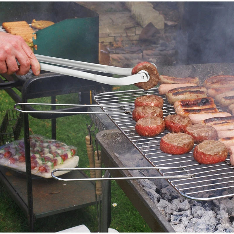 The tongs holding a sausage over a grill with perfect control. A must-have among kitchen tongs for efficient grilling.