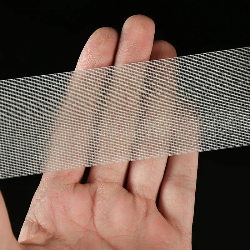 Hands peeling off the double-sided mesh tape, demonstrating its strong adhesion and elasticity.