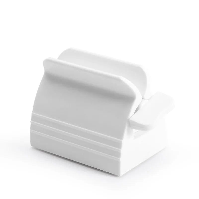 A white toothpaste squeezer is presented from various angles to showcase its simple and sleek design.