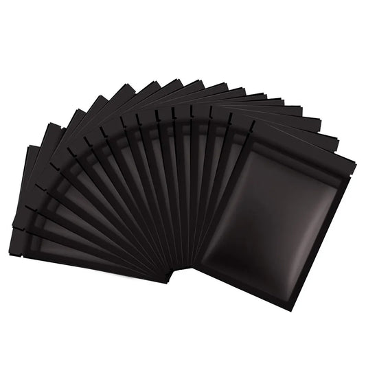 A collection of Matte Black Small Aluminum Foil Zip Lock Mylar Bags are fanned out, their odor-proof and moisture-resistant features ideal for preserving the freshness of contents.
