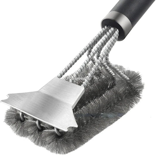 Close-up of a three-head barbecue grill brush with stainless steel bristles and a scraper. Ideal for efficient grill cleaning and maintenance.
