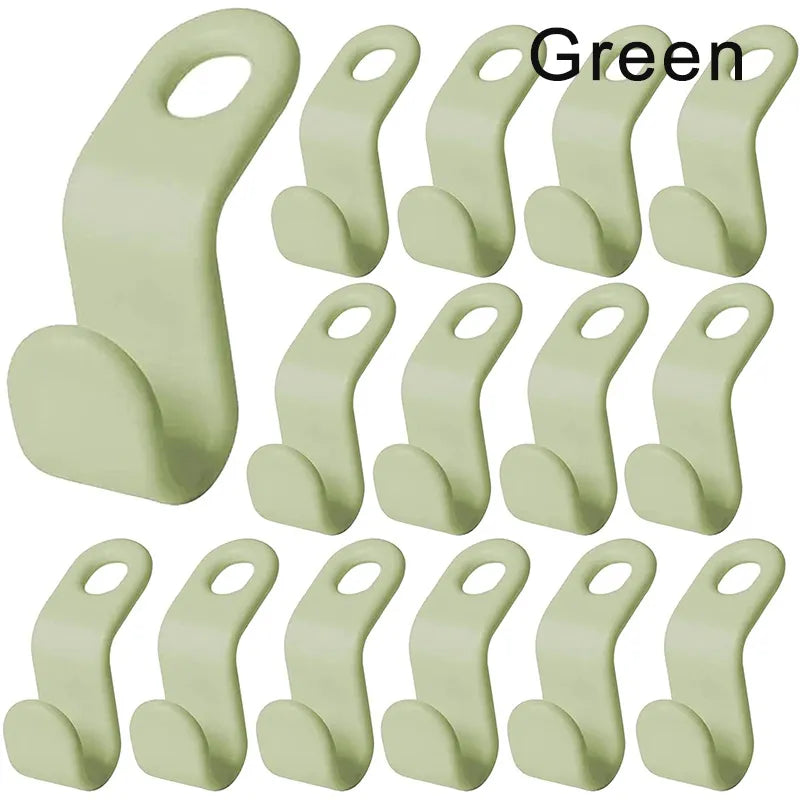 A collection of green, space-saving hanger connectors displayed against a white background, each with a slot for attaching another hanger.