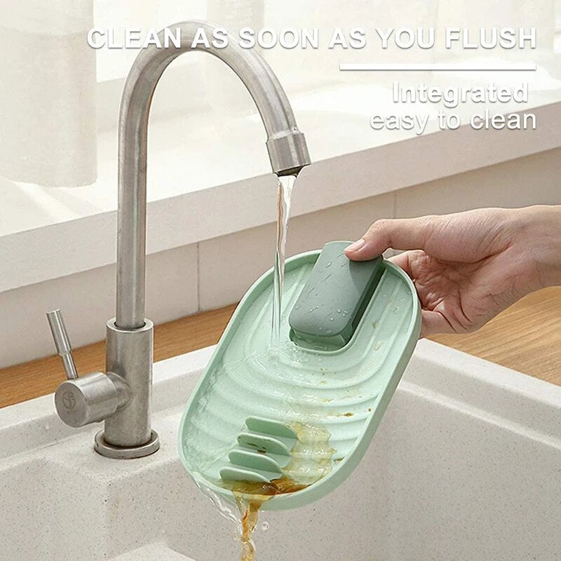 Hand washing a sage green silicone rack under a running tap, highlighting its easy-to-clean feature.