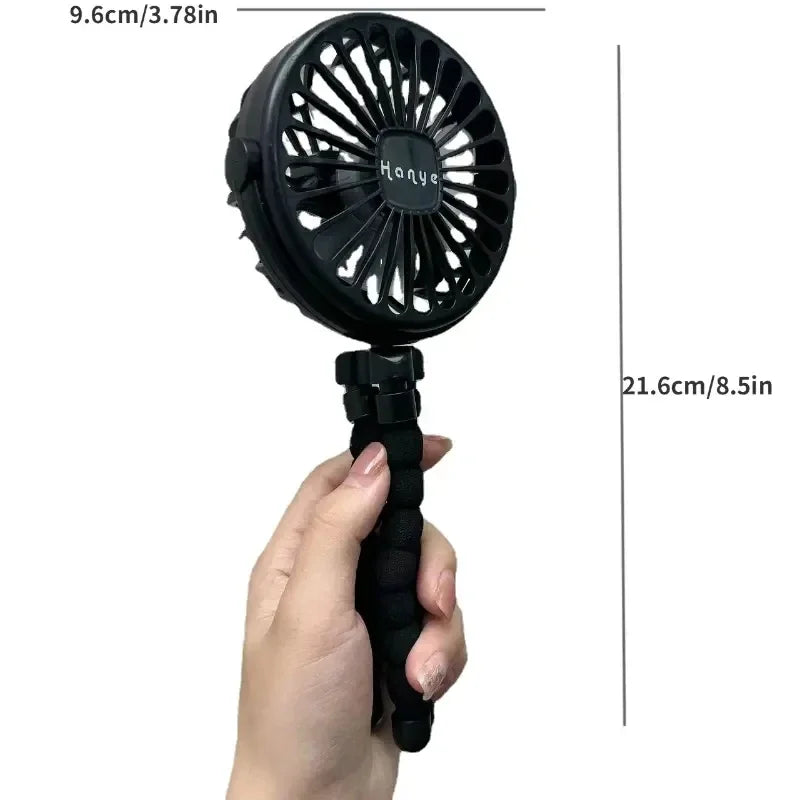Close-up of a battery-operated fan being held, showcasing its compact size and portability.