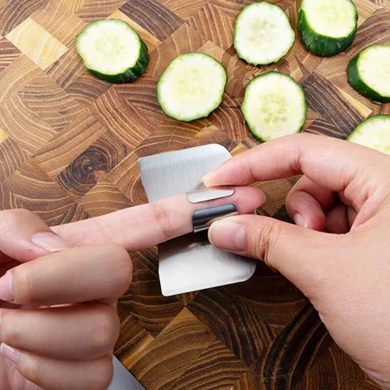 Close-up shots of the finger guard show the brushed stainless steel texture and the polished edges. It's placed on a finger, demonstrating fit and protection while cutting vegetables.