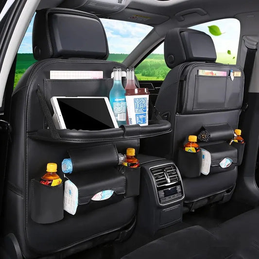Car Seat Back Organizer with Foldable Table Tray: The car seat back organizer in this image features a foldable table tray holding a tablet and water bottles. Multiple storage pockets are filled with snacks, drinks, and other items, showcasing the ample storage space and convenience it provides.