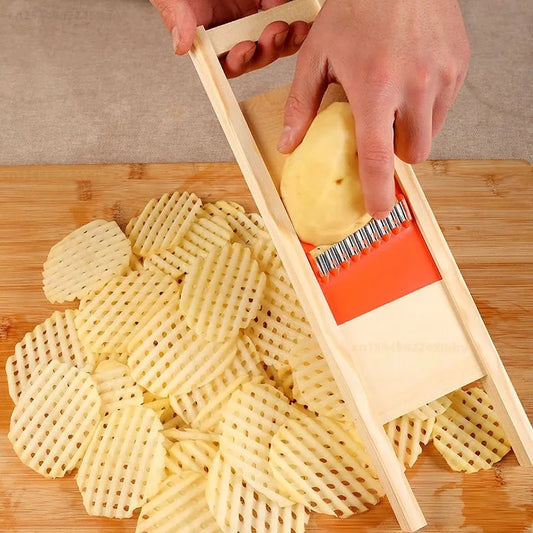 The image displays a person using a wooden-handled potato slicer with an orange base and a grid of sharp metal blades, cutting a potato into a crisscross pattern. There are multiple perfectly sliced grid-shaped potato pieces on a bamboo cutting board, suggesting the slicer's efficient and precise cutting ability.