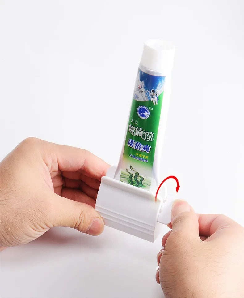 Hands are shown placing a toothpaste tube into the white squeezer, demonstrating ease of use.