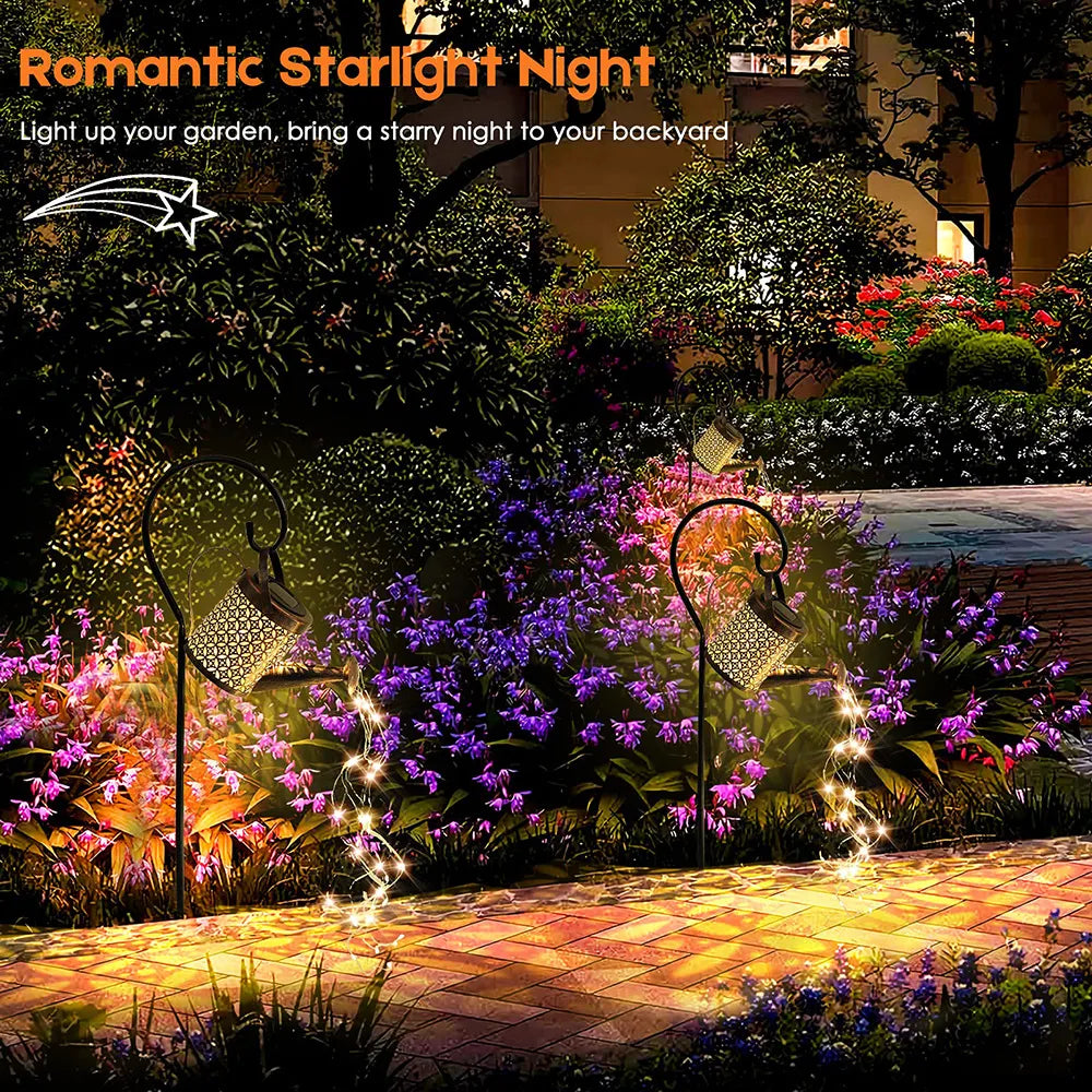 A nighttime scene featuring the Solar Watering Can Light casting a warm, enchanting glow over a flower bed. Great example of solar yard lights.