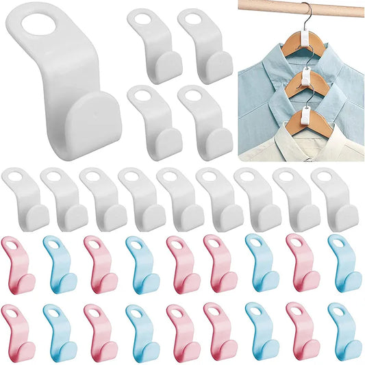 An array of white clothes hanger connector hooks is displayed, each with a simple design featuring a slot at one end to attach to a hanger and a hook at the other. A demonstration shows blue shirts neatly organized on wooden hangers which are interconnected by the white hooks, illustrating the space-saving benefit.