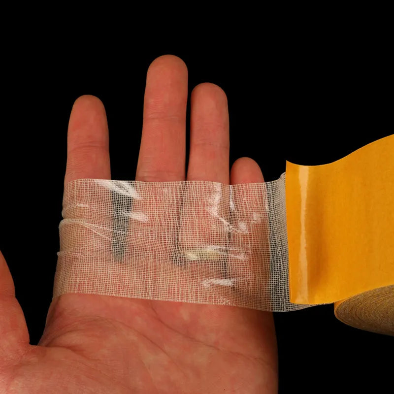 A demonstration of the tape's transparency as a hand overlaps it 