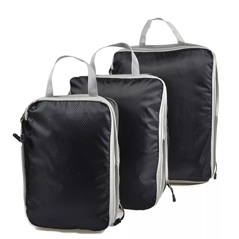 Three black nylon packing cubes with mesh tops, in different sizes, stacked on top of each other.