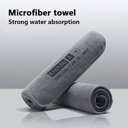 Rolled grey microfiber towel with text emphasizing its strong water absorption.