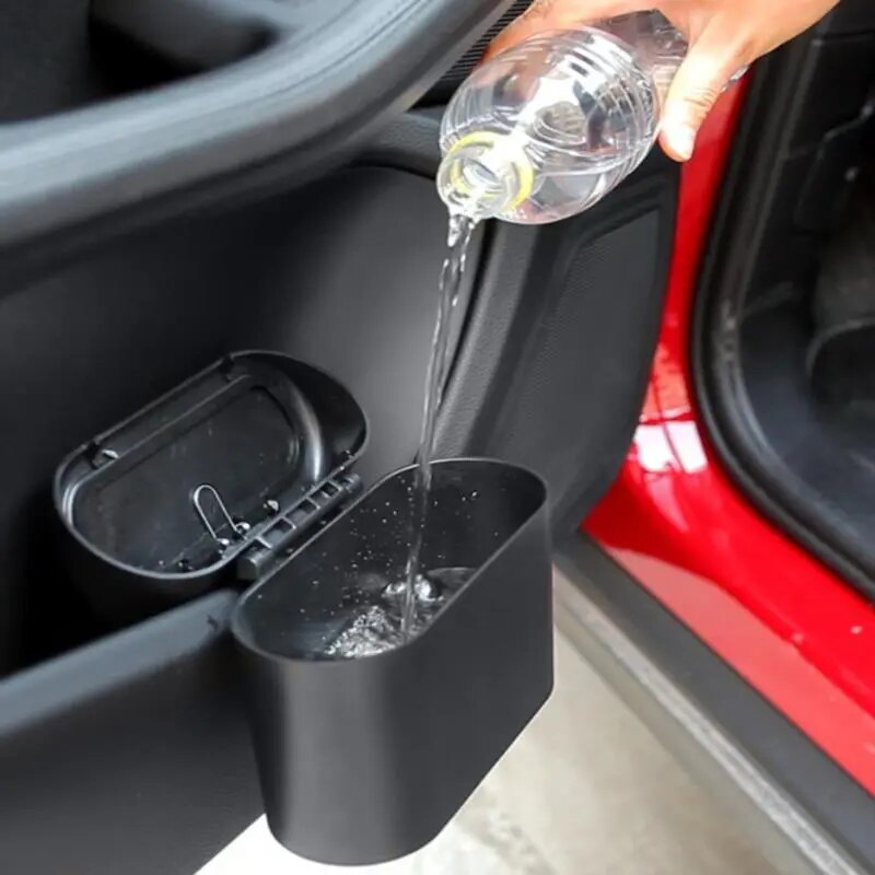 An image showing the car trash bin in use; a hand is throwing trash into it, illustrating its practicality in keeping the car clean.