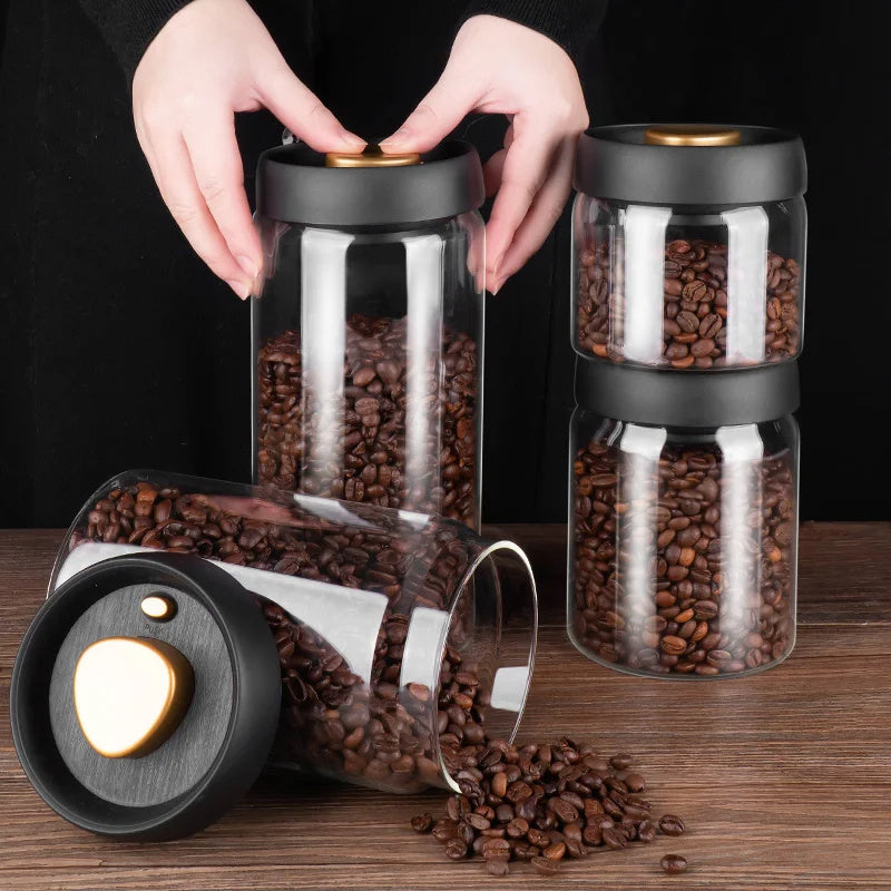 Black Coffee Beans Glass Airtight Canister: A pair of hands holds the Black Coffee Beans Glass Airtight Canister filled with coffee beans. The minimalist design of the airtight container ensures coffee remains fresh and flavorful.