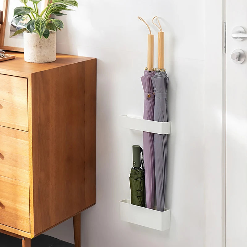 A stylish, Japan-style umbrella stand mounted on the wall, with a small plant next to it, blending functionality with modern decor.